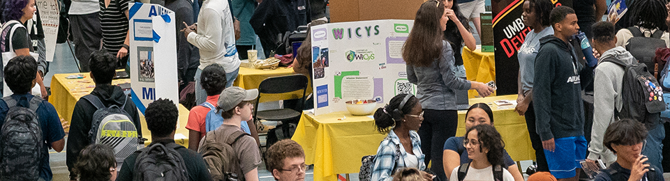 Students in a crowd of tables of student organizations promoting their groups.